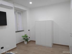 una habitación con una pared blanca y una maceta en Maison Cleo, en Torre Annunziata