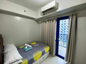a small bed in a room with a window at LIAM's Staycation in Manila +77 photos