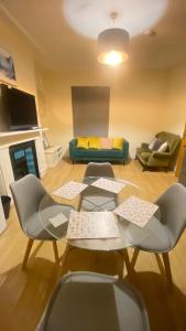 a living room with a table and chairs and a couch at Evo Green Gravesend 2 bed Apartment, 2 mins Station, Town Centre in Gravesend +10 photos