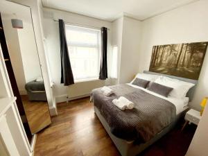 a bedroom with a large bed and a window at Evo Green Gravesend 2 bed Apartment, 2 mins Station, Town Centre in Gravesend