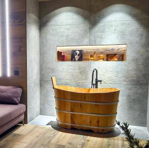 PiatedaAgarthi Suites - Valtellina的浴室配有带水槽的木制浴缸