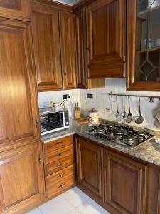 a kitchen with wooden cabinets and a stove top oven at Casa Matilde in Sestu