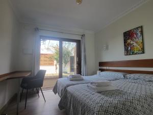 a bedroom with a bed and a desk and a window at LA OLA Tarifa in Tarifa