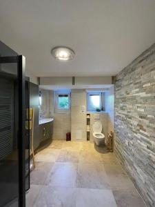 CouvetAppartement Wonder的一间带卫生间和石墙的浴室