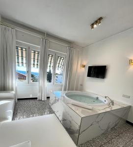 a large white bathroom with a tub in a room at Eveline 2 - Piscina Privata o Jacuzzi in Sanremo