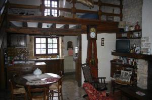 a kitchen with a table and a clock in a room at Longère du ruisseau in Armes