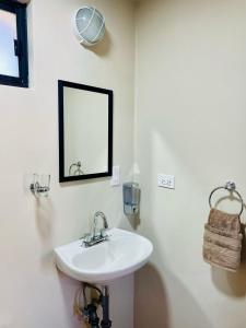 Un baño blanco con lavabo y espejo. en Posada Los Olivos, en Loreto 3 fotos más