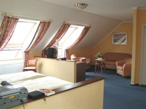 Habitación de hotel con cama y sala de estar. en Hotel Restaurant Bootshaus en Achim