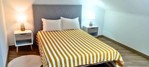 ein Schlafzimmer mit einem Bett mit zwei Nachttischen und zwei Lampen in der Unterkunft Home Away in Vila Nova de Milfontes
