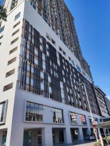a tall white building with black windows at 2-5pax Cozy Condo 2 in The Grand SS15 Sunway 2BRs in Subang Jaya