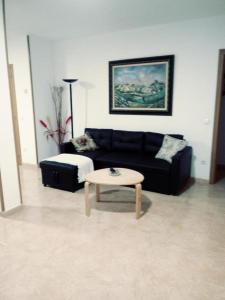 a living room with a black couch and a coffee table at ODELOT Toledo in Olías del Rey