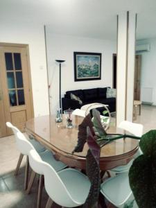 a living room with a glass table and white chairs at ODELOT Toledo in Olías del Rey