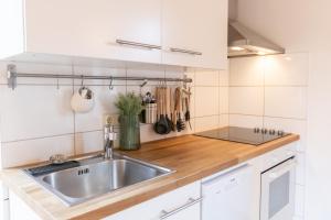 ツィローにあるBruns Wiek Haus MAX einfach MEERのキッチン(ステンレス製のシンク、木製カウンタートップ付)