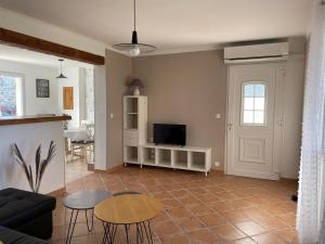 a living room with a couch and a tv at "La Pinède" à l'ombre des pins tout simplement in Montfrin