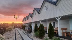 a row of houses with a sunset in the background at Domki Scandinavia in Rowy