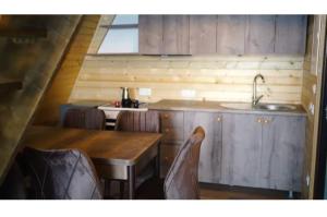 a kitchen with a wooden table and a sink at Pamje Malore in Mitrovica