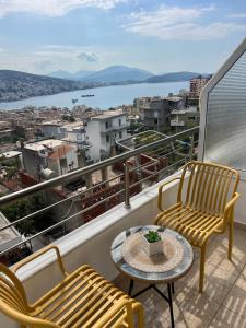 a balcony with two chairs and a table and a view at Apartments Sadiku with swimming pool & jacuzzi in Sarandë
