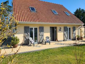une maison avec 2 chaises sur une terrasse dans l'établissement Villa " Rosina ", à Fort-Mahon-Plage