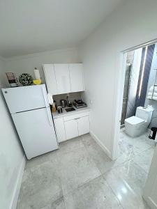 a kitchen with a white refrigerator and a toilet at Modern and cozy room in North Miami Beach