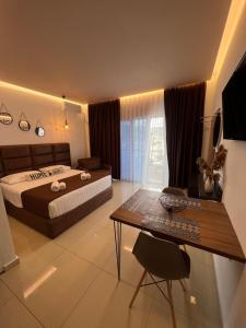 a bedroom with a bed and a desk and a table at Apartments Sadiku with swimming pool & jacuzzi in Sarandë +28 photos