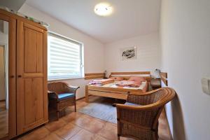 a bedroom with a bed and two chairs and a window at Słoneczny Dom in Poddąbie