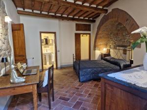 a bedroom with a bed and a desk and a table at Roma 88 in Lucignano