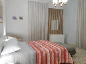 a bedroom with a bed with a striped blanket at Risorgimento House in Catania