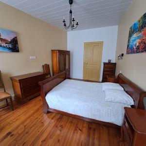 a bedroom with a large bed and wooden floors at StGoFeelGood in Saint-Gaudens