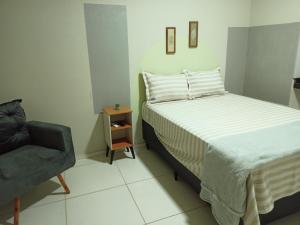 a small bedroom with a bed and a chair at NORTE HOTEL Guaraciaba in Guaraciaba do Norte
