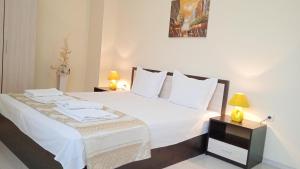 a bedroom with a bed with white sheets and pillows at Апартамент в непосредствена близост до плажа in Burgas City