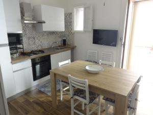 Una cocina con una mesa de madera y una mesa y sillas. en Thalìa, en Trapani