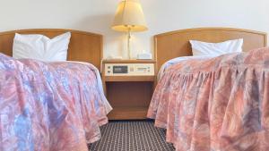 Postel nebo postele na pokoji v ubytování Shingu UI Hotel