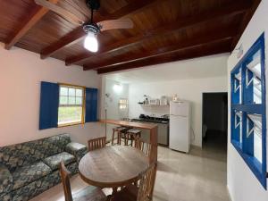 a kitchen and living room with a table and a couch at Casas Aguas Cantantes in Ubatuba