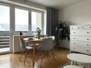 a dining room with a table and chairs and windows at Apartament Babie Lato in Szczawnica
