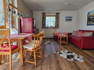 a living room with a table and a red couch at Landhaus Eibelesee in Oberstaufen
