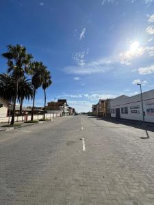 een lege straat met palmbomen langs de kant van de weg bij Central Self Catering in Swakopmund