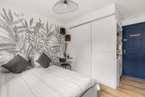 a bedroom with a bed with a tropical wallpaper at Le Trésor Du Port- Plein Coeur du Vieux Port in Marseille