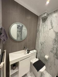 a bathroom with a toilet and a sink and a mirror at Αικατερίνα in Kozani +24 photos