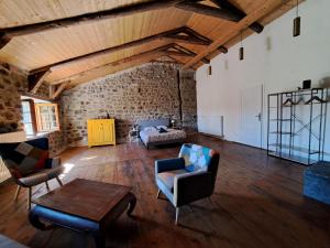a living room with a couch and chairs and a table at La Maisonnette in Présailles +1 photo