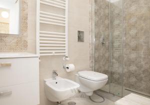 a bathroom with a toilet and a sink and a shower at WHITE SOFIA - uno sguardo sul mare in Bari
