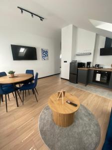 a living room with a table and chairs and a kitchen at Harmony House - Appartement Blue in Kołczewo