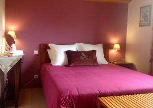 a bedroom with a purple bed with white pillows at Les Arums de Sanguinet in Sanguinet