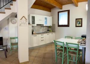 a kitchen with white cabinets and a table and chairs at Il Ghiandolino in Imola