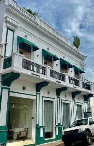 a building with a car parked in front of it at Boutique Hotel Casa Grande, Mango Tango Suite in Santo Domingo
