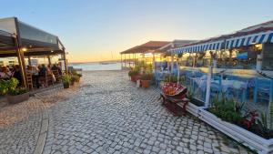 Una calle adoquinada con mesas y sillas y un restaurante. en PoolHouse EstrelasDourada ALVOR, en Alvor
