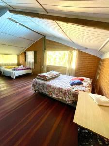 une chambre avec deux lits dans une pièce avec parquet dans l'établissement Recanto ágape chalés e cabana, à Rosas