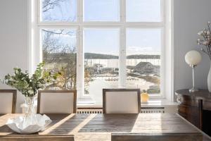a dining room with a table and a large window at Small castle from 1915 in Kalvøya