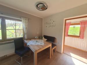 a dining room with a wooden table and two chairs at Pension Scheuerbichl in Bischofswiesen