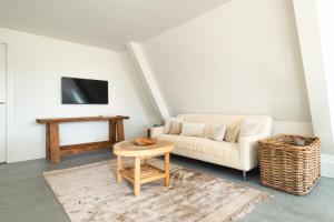 a living room with a couch and a table at Appartement N05 Bakboord & Stuurboord in Oost-Vlieland