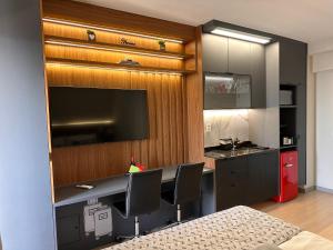 cocina con escritorio con sillas y fregadero en Studio NOVO 100m Av Paulista, en São Paulo